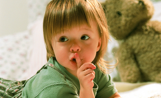 Kleinkind hält Finger vorm Mund