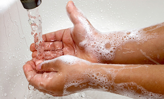 Kind wäscht seine Hände mit Seife