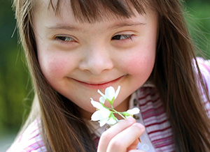 Mädchen mit Behinderung hält Blume