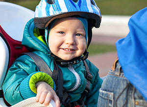 Junge mit Helm sitzt im Fahrradsitz