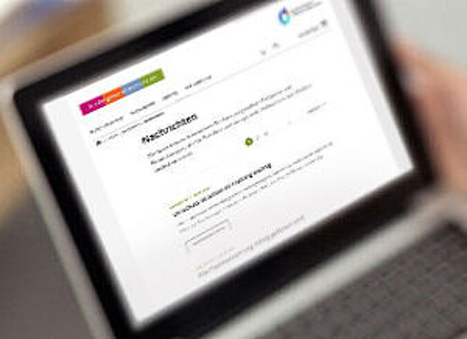Ein Mann informiert sich per Laptop über die neuesten Nachrichten bezüglich Kindergesundheit.