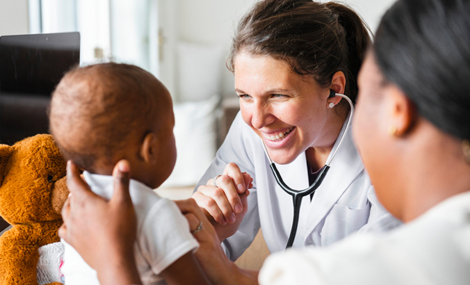 Ärztin hört mit einem Stethoskop ein Kleinkind ab 