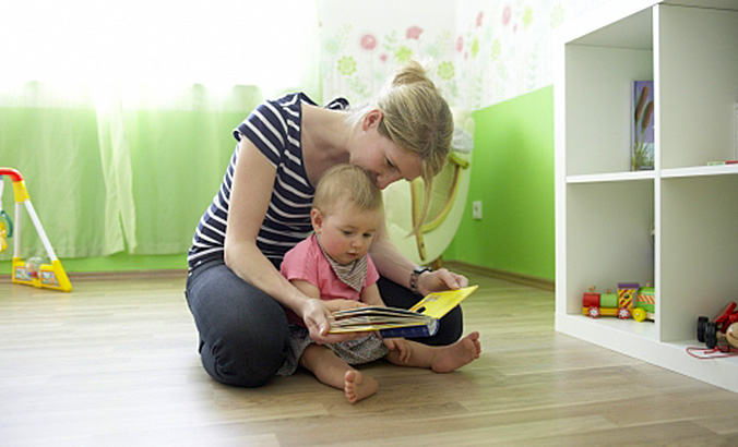 Frau liest Kind etwas vor