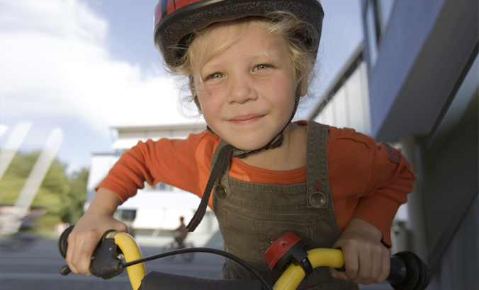 Mädchen mit Helm auf Fahrrad