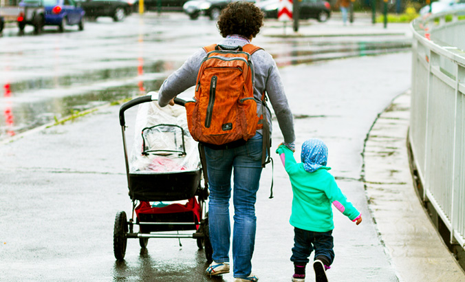 Kind läuft an der Hand der Mutter und ist der Straße abgewandt