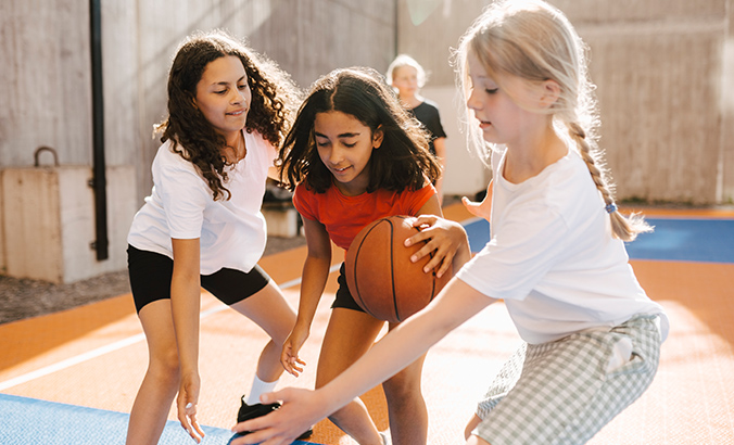 Mädchen spielen Basketball