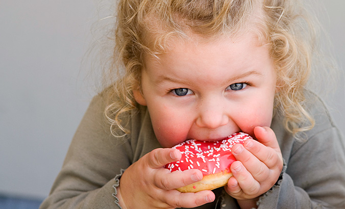 Übergewichtiges Kind isst Donut