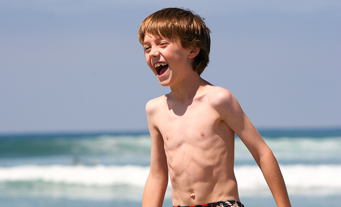 Untergewichtiger Junge am Strand