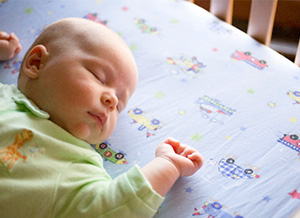 Baby schläft im Gitterbett