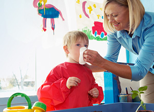 Frau putzt einem Jungen die Nase