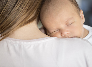 Mutter hält schlafendes Baby auf dem Arm