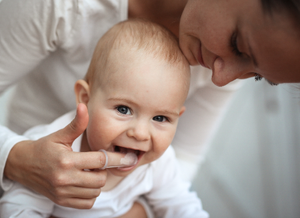 Mutter befühlt die wachsenden Zähne vom Baby