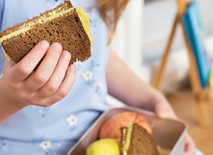 Kind hält Käsebrot in der Hand