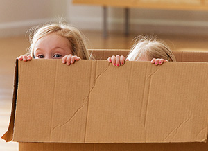 Zwei Kinder in einem Pappkarton