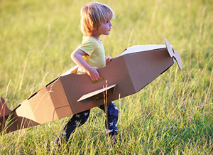 Kind mit Pappflugzeug