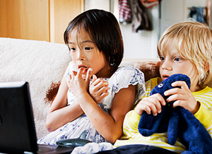 Zwei Kinder schauen ängstlich auf Bildschrim