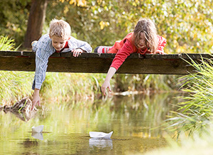 Kinder spielen am Wasser