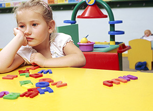 Nachdenkliches Mädchen an Spieltisch