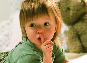 Kind hält Finger vorm Mund