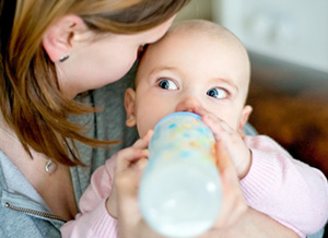 Mutter gibt Baby die Flasche