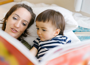 Mutter schaut mit ihrem Kind ein Bilderbuch an