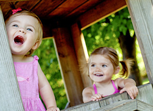 Kinder spielen im Holzhaus