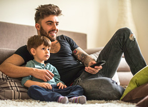 Vater schaut gemeinsam mit seinem Sohn Fernsehen