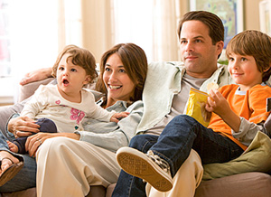 Eine Familie sitzt gemeinsam vor dem Fernseher