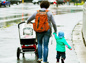 Kind läuft an der Hand der Mutter und ist der Straße abgewandt