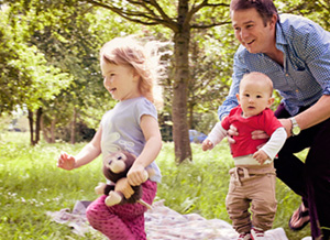 Kinder spielen draußen mit Vater