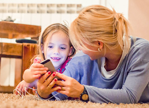 Mutter und Tochter schauen gemeinsam auf ein Smartphone