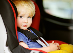 Junge sitzt sicher angeschnallt im Kindersitz