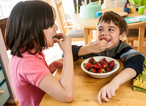 Zwei Kinder essen Erdbeeren