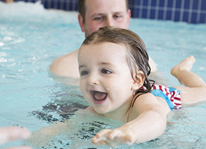 Kind beim Schwimmen lernen im Hallenbad